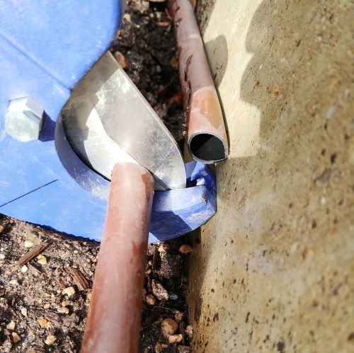 Cutting out a damages section of drip line with pvc cutters