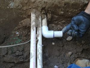 Preparing the PVC main line for the first sprinkler valve to be installed